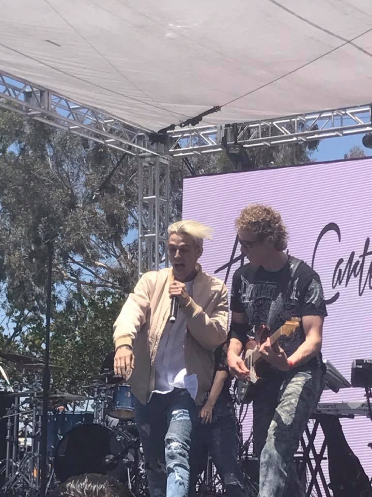 Aaron Carter singing on stage while Erik Madsen plays guitar beside him at Wango Tango